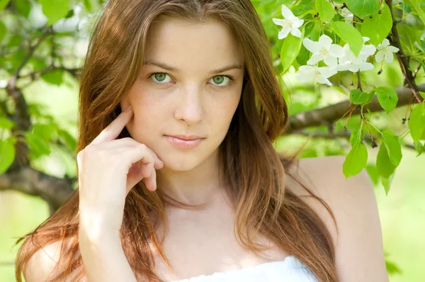 Beautiful young woman relaxing in apple tree garden — Stock Photo, Image