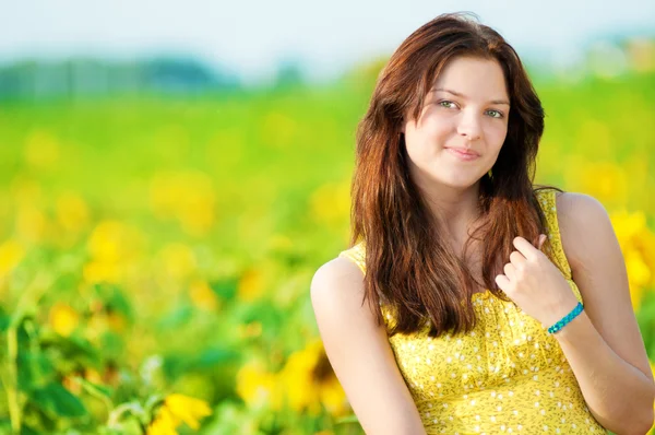O femeie frumoasă într-un câmp de floarea-soarelui — Fotografie, imagine de stoc