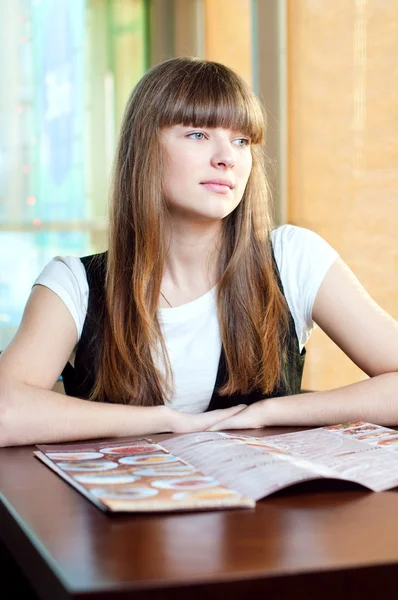 Μια νεαρή γυναίκα σε ένα καφέ. — Φωτογραφία Αρχείου