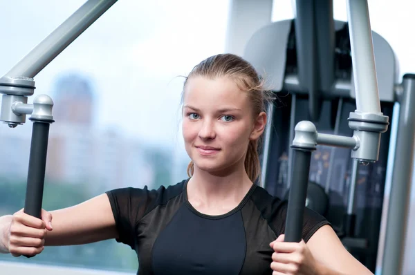 Junge Frau beim Turnen im Fitnessstudio — Stockfoto