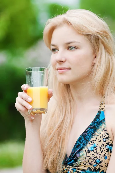 Usmívající se žena pít pomerančový džus — Stock fotografie