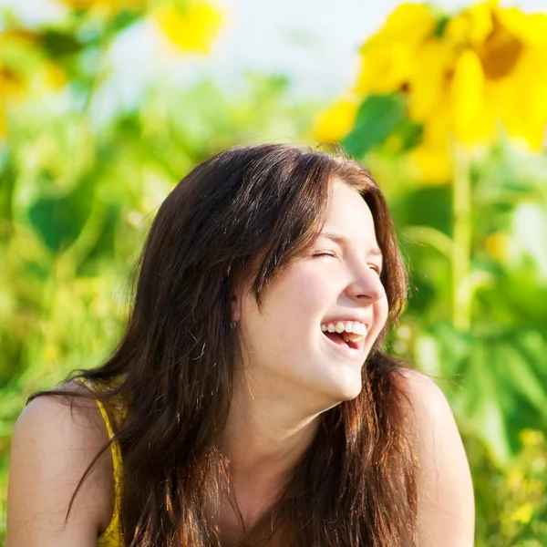 Mooie vrouw in een zonnebloem veld — Stockfoto