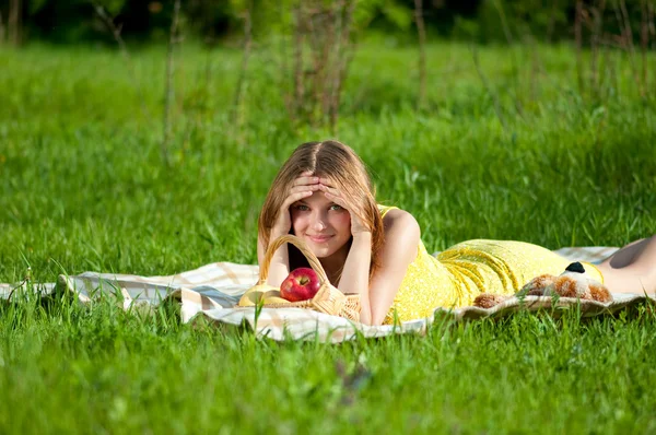 Mooie jonge vrouw op picknick met vruchten — Stockfoto