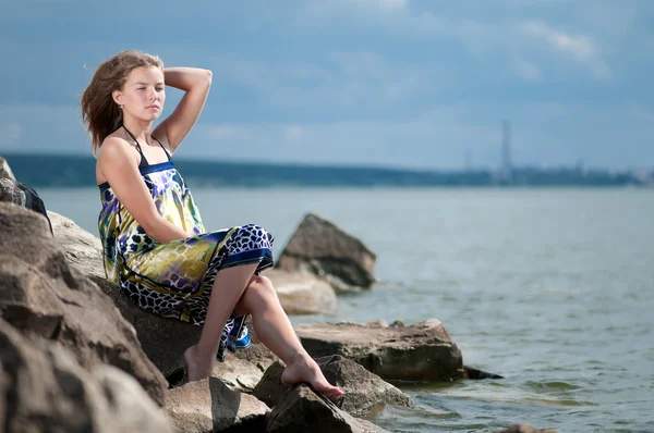 Mujer triste en vestido sentado en la roca —  Fotos de Stock