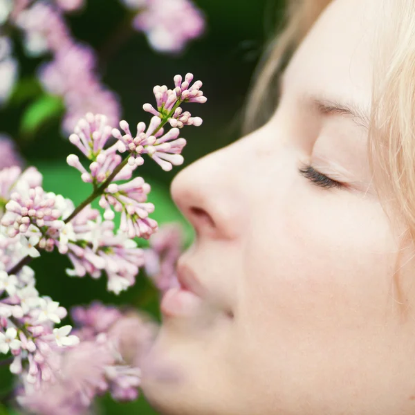 Frau mit fliederfarbener Blume im Gesicht — Stockfoto