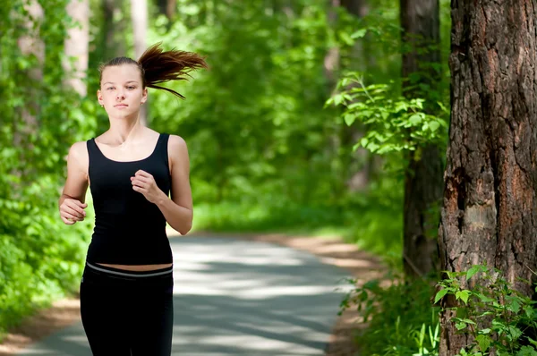 Mujer corriendo en el parque verde — Foto de Stock