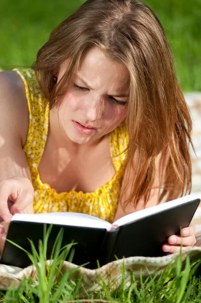 Beautiful young woman reading book outdoor — Stock Photo, Image
