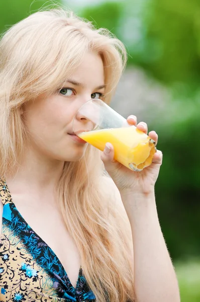 Lächelnde Frau trinkt Orangensaft — Stockfoto