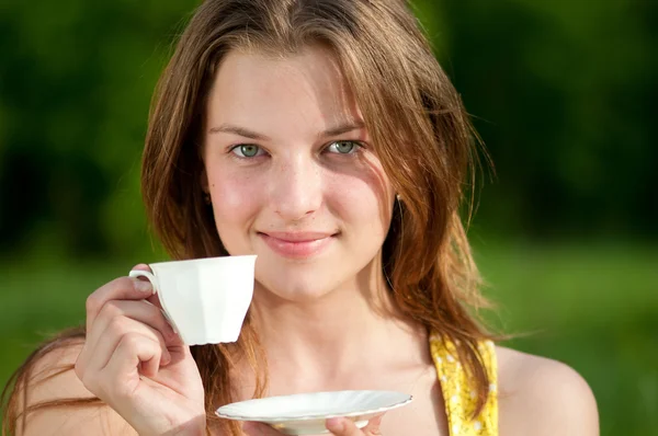 Beautiful young woman drink hot tee outdoor — Stock Photo, Image
