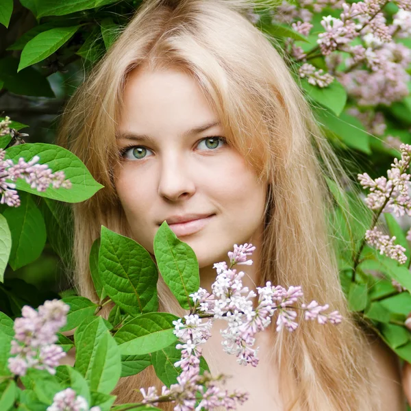 Femme avec fleur de lilas sur le visage — Photo