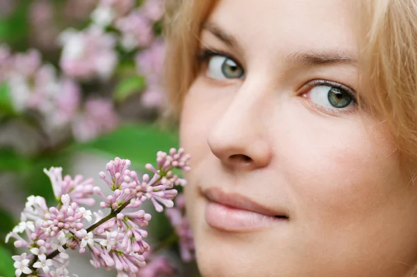 Frau mit fliederfarbener Blume im Gesicht — Stockfoto