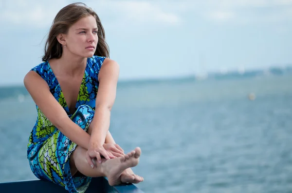 Sad woman sitting over sea at summer day — Stock Photo, Image