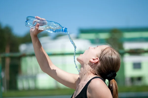 Молодая женщина пьет воду после тренировки — стоковое фото