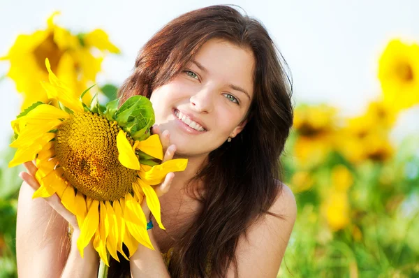 Krásná žena ve slunečnicovém poli — Stock fotografie