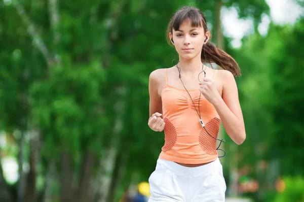 Menina adolescente correndo no parque verde Fotografias De Stock Royalty-Free