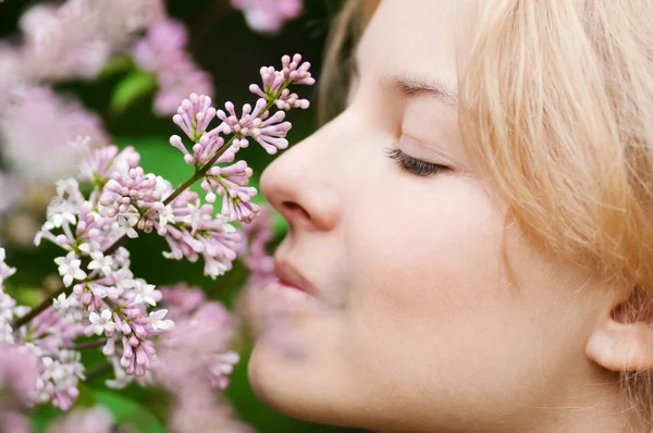 Woman with lilac flower on face Stock Image