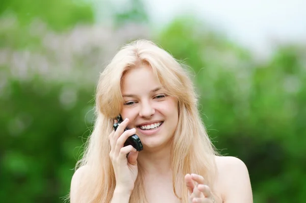 Young woman using phone at park — Stock Photo, Image