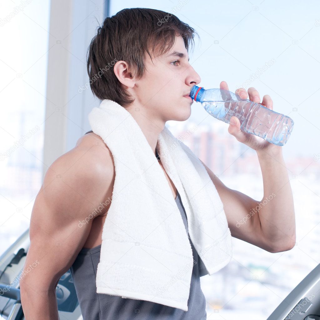 Man at the gym drinking water