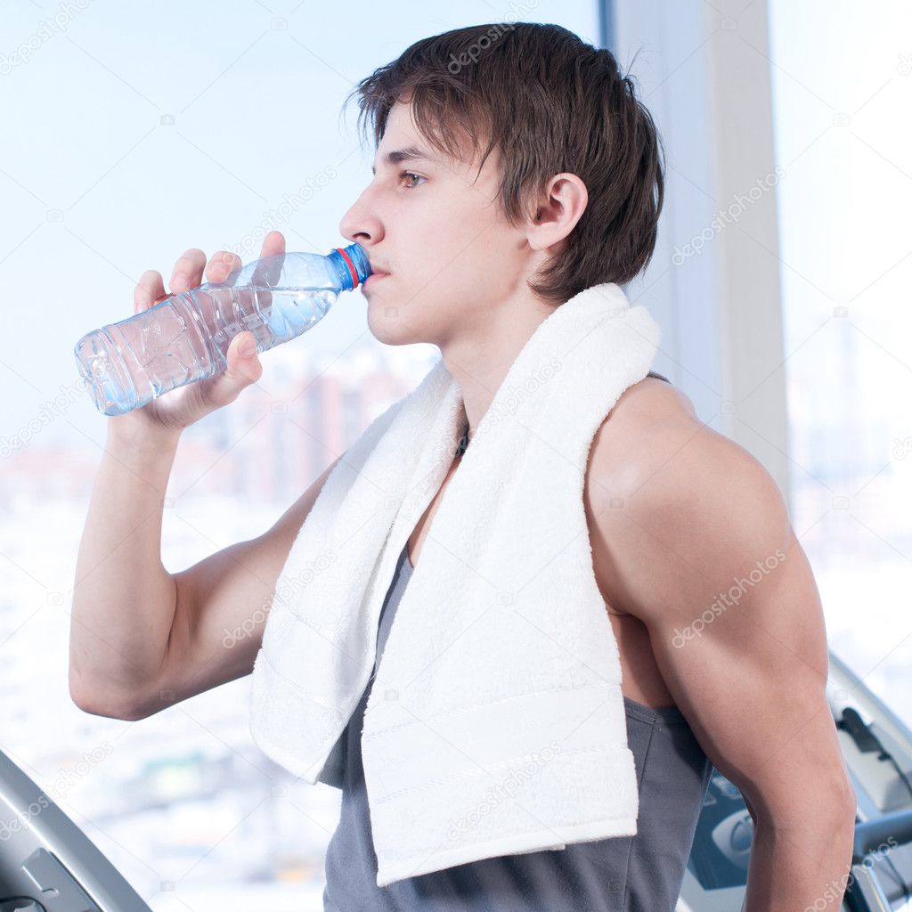 Man at the gym drinking water