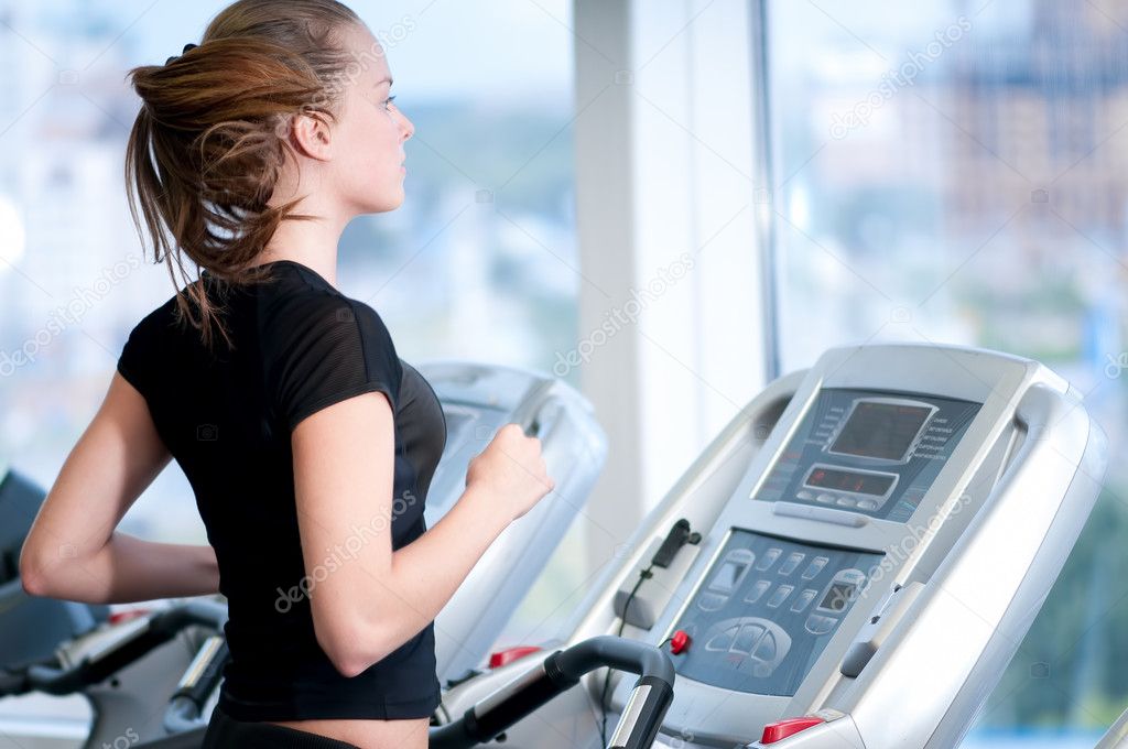 Young woman at the gym. Run on a machine