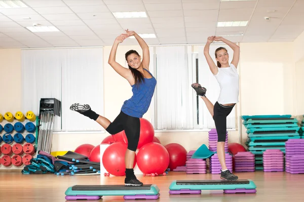 Dos mujeres haciendo ejercicio de estiramiento en el gimnasio —  Fotos de Stock