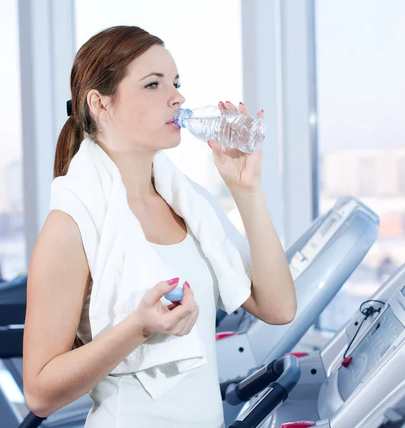 Young woman at the gym exercising. Drink — Stock Photo, Image