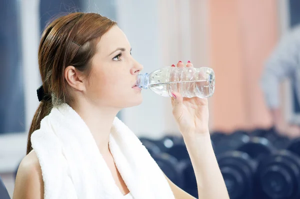 Vacker sport kvinna dricka vatten på gym — Stockfoto