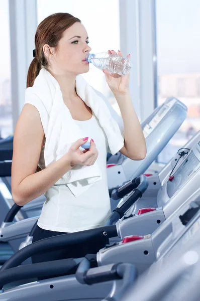 Ung kvinna på gym utövar. drink — Stockfoto