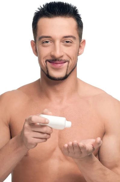 Giovane uomo che applica la crema. Cosmetici — Foto Stock