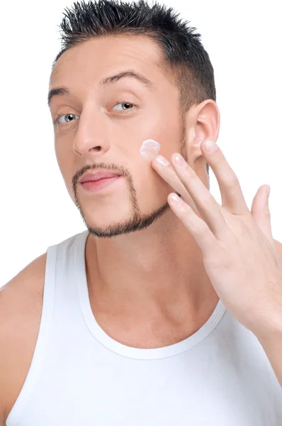 Knappe man mannelijke crème toe te passen op gezicht — Stockfoto