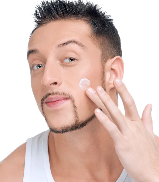 Handsome man applying male creme on face — Stock Photo, Image