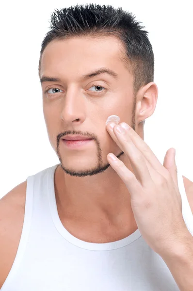 Bello uomo applicare maschio creme su faccia — Foto Stock