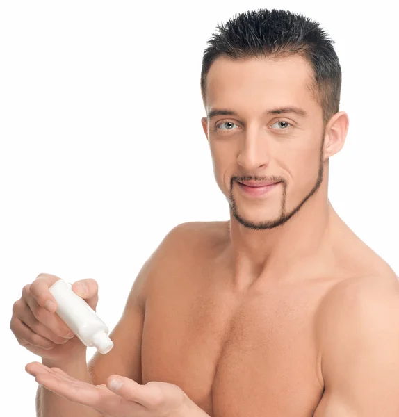 Mladý muž použitím krém. kosmetické — Stock fotografie