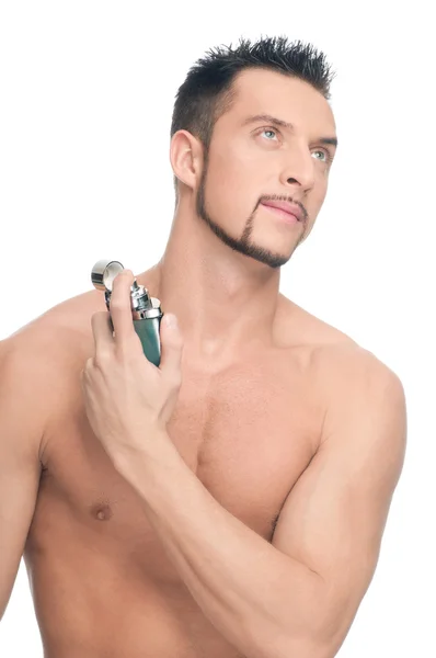 Joven hombre guapo aplicando perfume — Foto de Stock