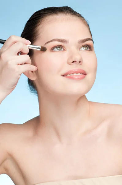 Schöne junge erwachsene Frau Anwendung kosmetischer Schattenbürste — Stockfoto