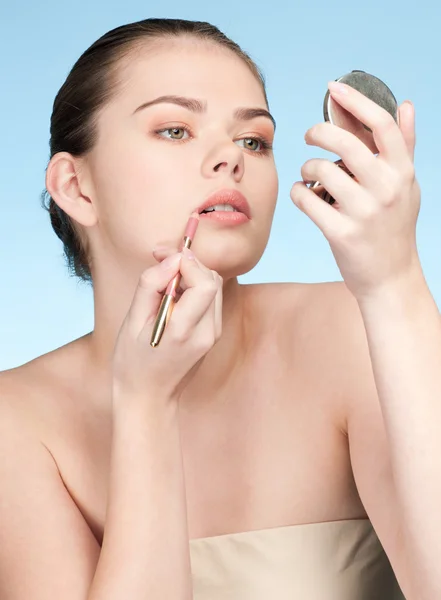 Mulher adulta jovem bonita aplicando lápis de batom cosmético — Fotografia de Stock