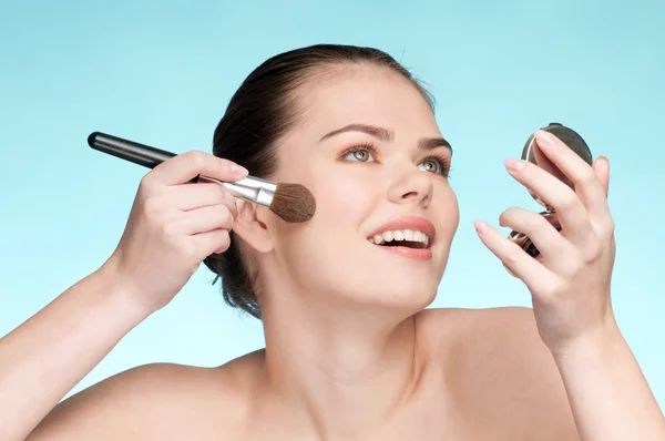 Mooie jonge volwassen vrouw cosmetische poeder borstel toepassen — Stockfoto