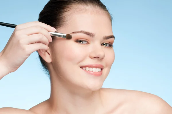 Vacker ung vuxen kvinna tillämpa kosmetiska shadow brush — Stockfoto