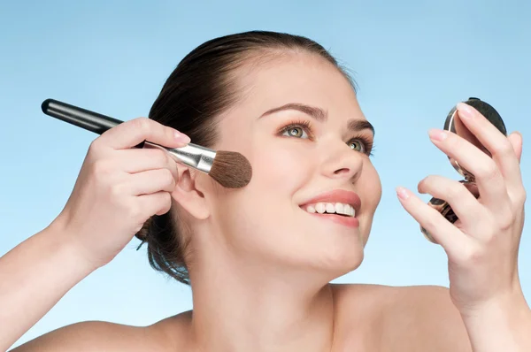 Beautiful young adult woman applying cosmetic powder brush — Stock Photo, Image