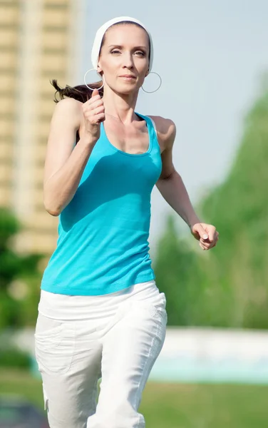 Beautiful woman running in green park — Stock Photo, Image