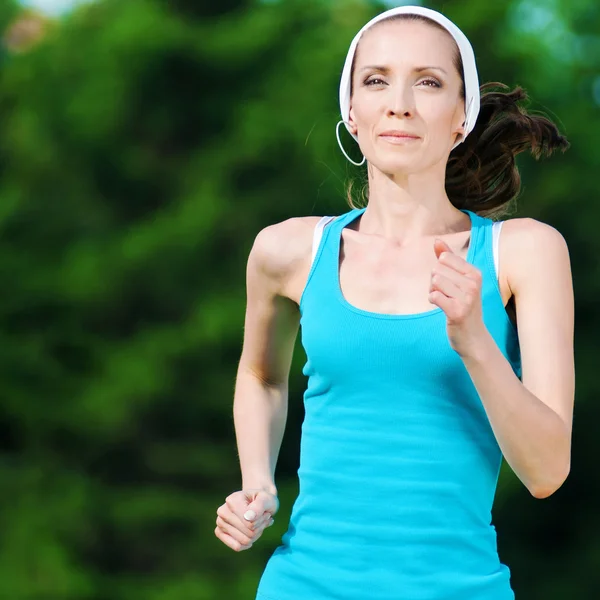 Beautiful woman running in green park — Stock Photo, Image