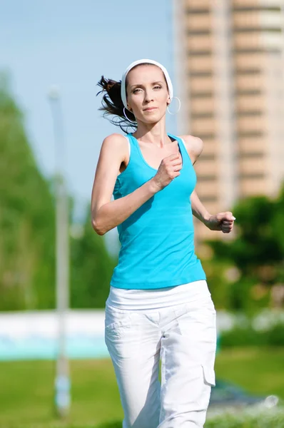 Beautiful woman running in green park — Stock Photo, Image