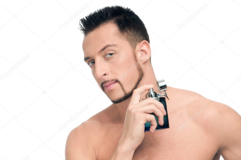 Young handsome man applying perfume