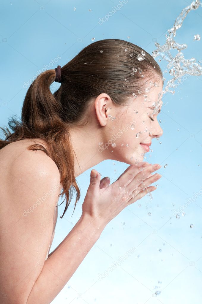 Portrait of beautiful emotional woman washing face