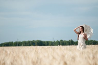 buğday alanında yürüyen yalnız bir kadın. zaman aşımına uğradı.