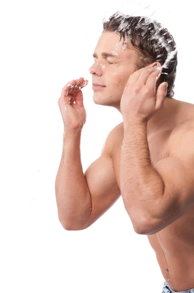 Молодий чоловік миє обличчя — стокове фото