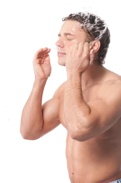 Молодий чоловік миє обличчя — стокове фото