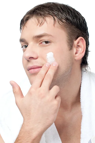 Hombre poniéndose crema loción en la cara — Foto de Stock