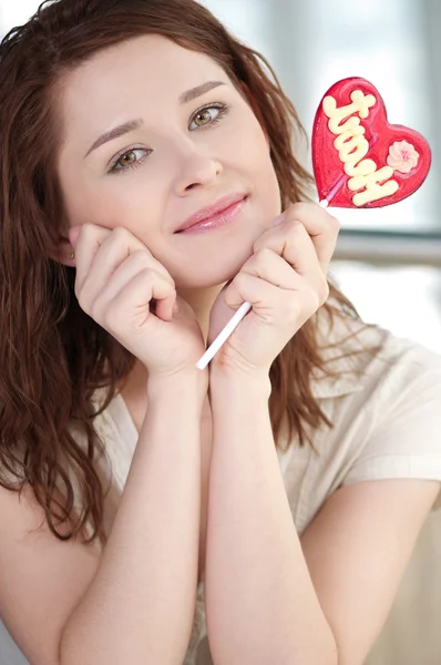 Pretty woman with candy heart — Stock Photo, Image