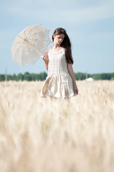 Eenzame vrouw lopen in een tarweveld. getimede. — Stockfoto